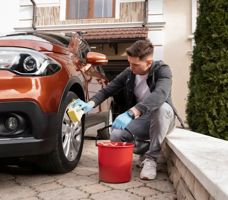 Lavage auto à domicile Couesmes-Vaucé : professionnel intervenant sur un véhicule